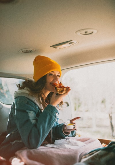 车里吃比萨饼的女人